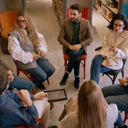 Group of people sitting around in a circle.