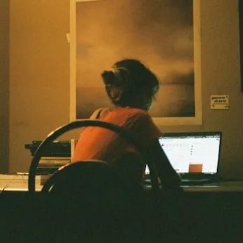 Smilding woman sitting on her couch with a laptop.